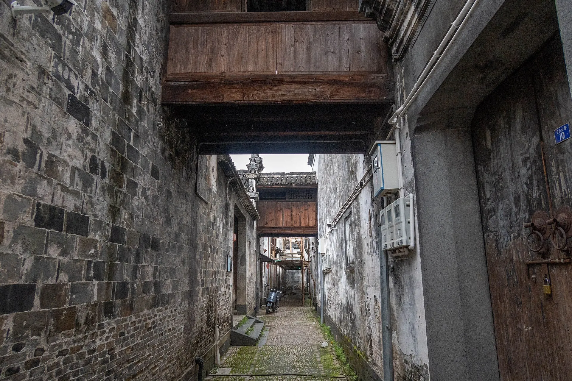 A lane in Chongren, crossed overhead by a covered passage linking the houses on either side.