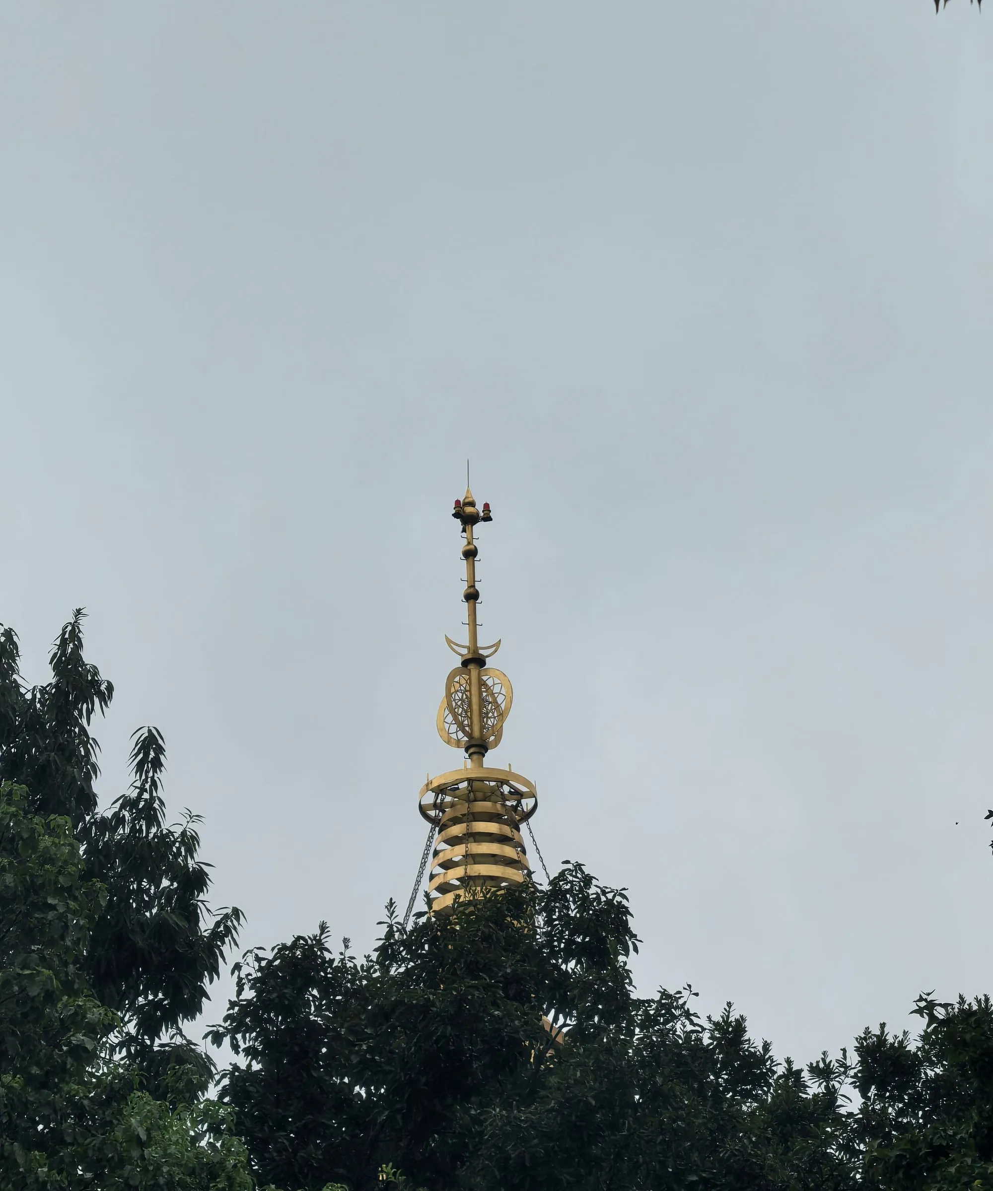 The Leifeng Pagoda we had longed to see — just the spire, above the trees.