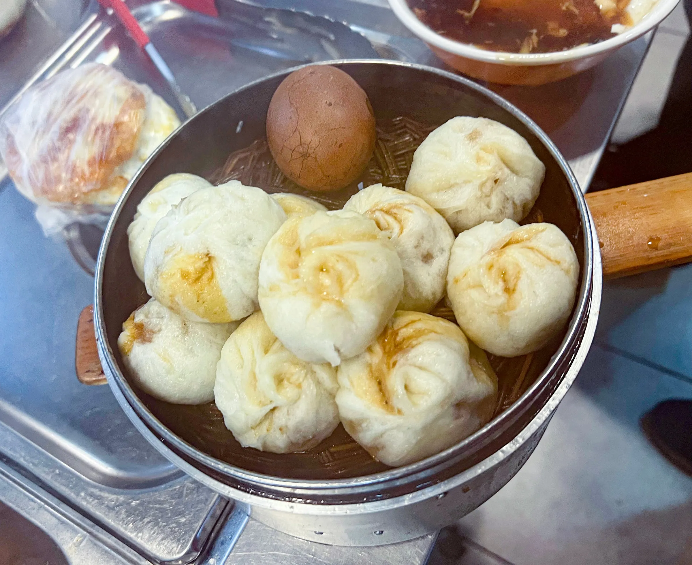 A steamer of Shengzhou xiaolongbao with a tea egg, at a snack shop in Beijing.